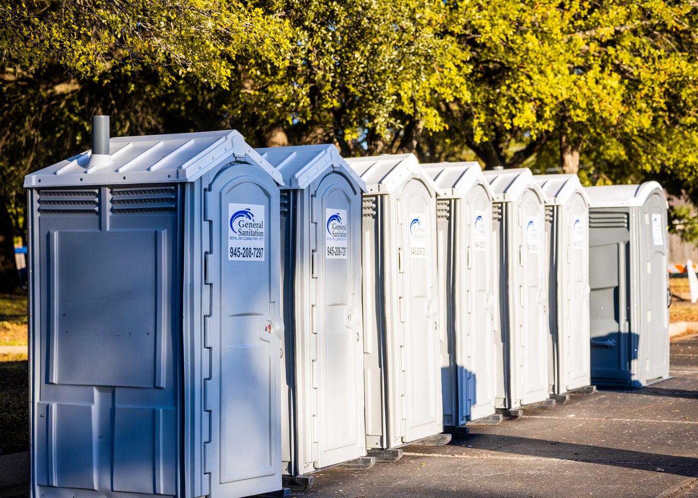 Multiple portable toilets aligned at an outdoor site